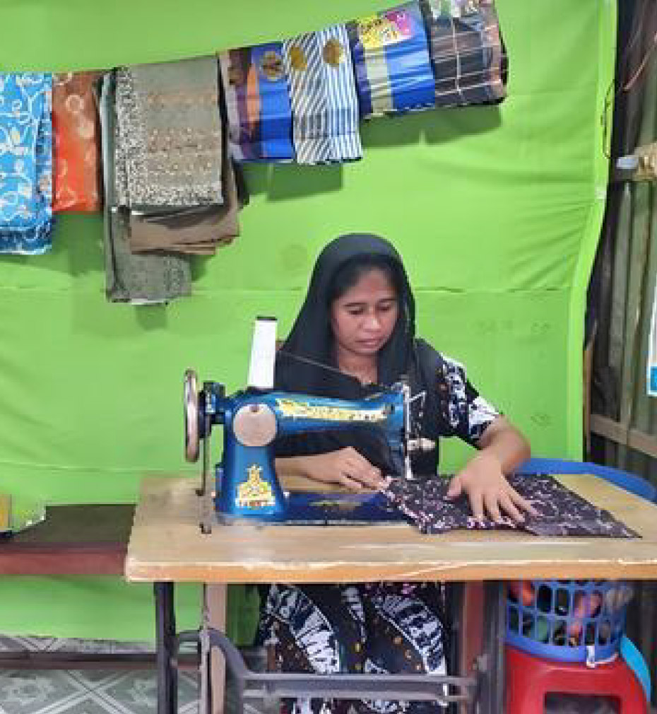Shila is busy sewing clothes at her tailor store